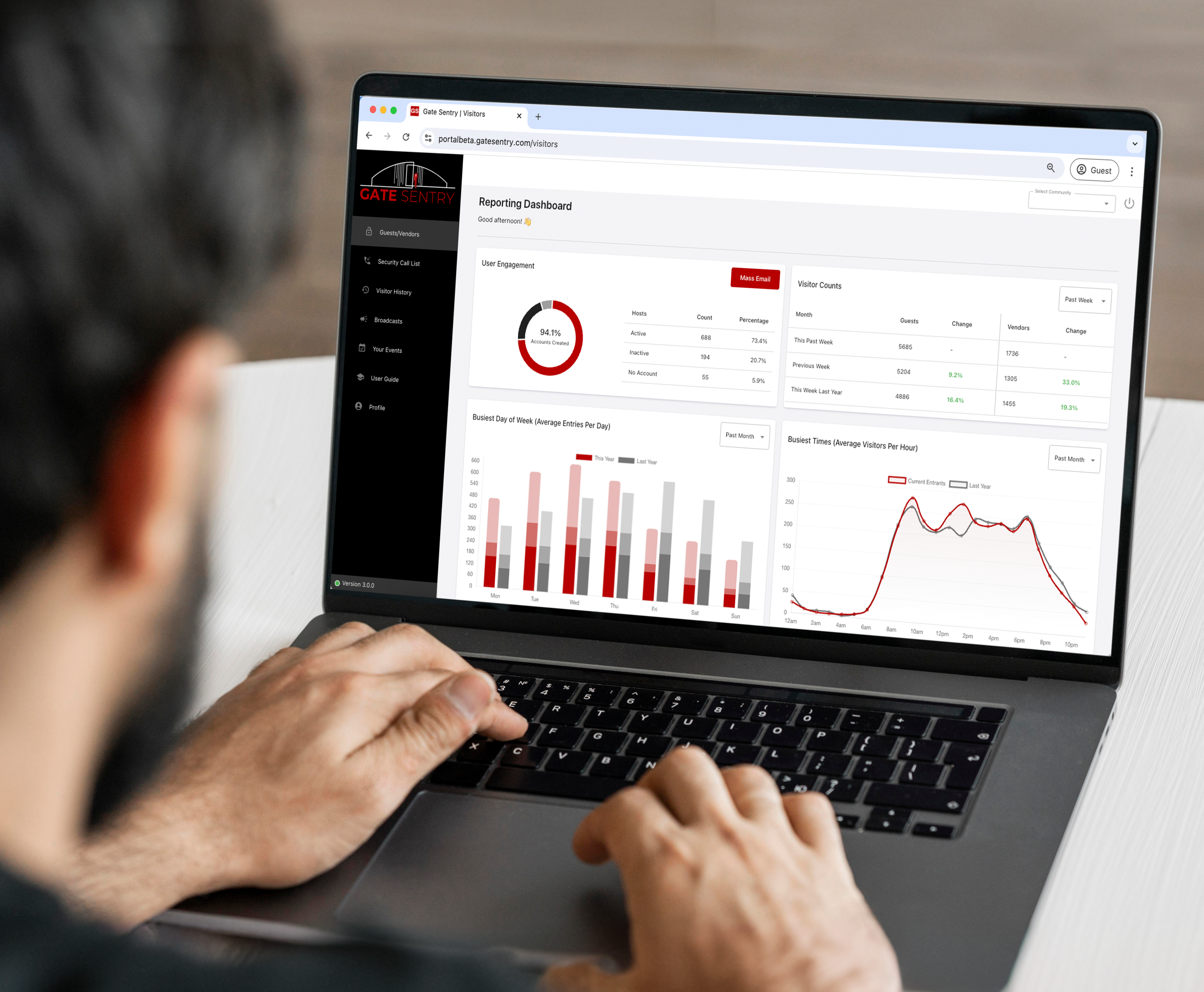 An image taken over the shoulder of a man working on a laptop, which displays the administrator reporting dashboard, showcasing the access control management interface.